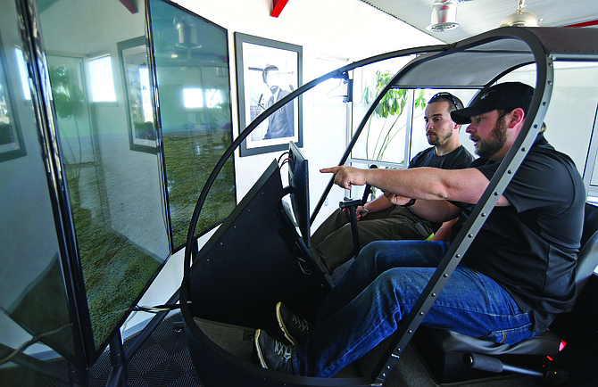 Photo by Matt Hinshaw. Guidance Aviation’s Adam Pasquarella, right, with Student Services works with Ryan Bertucci, an Embry-Riddle Aeronautical University engineering student, on their new helicopter simulator Friday afternoon at the Prescott Airport.